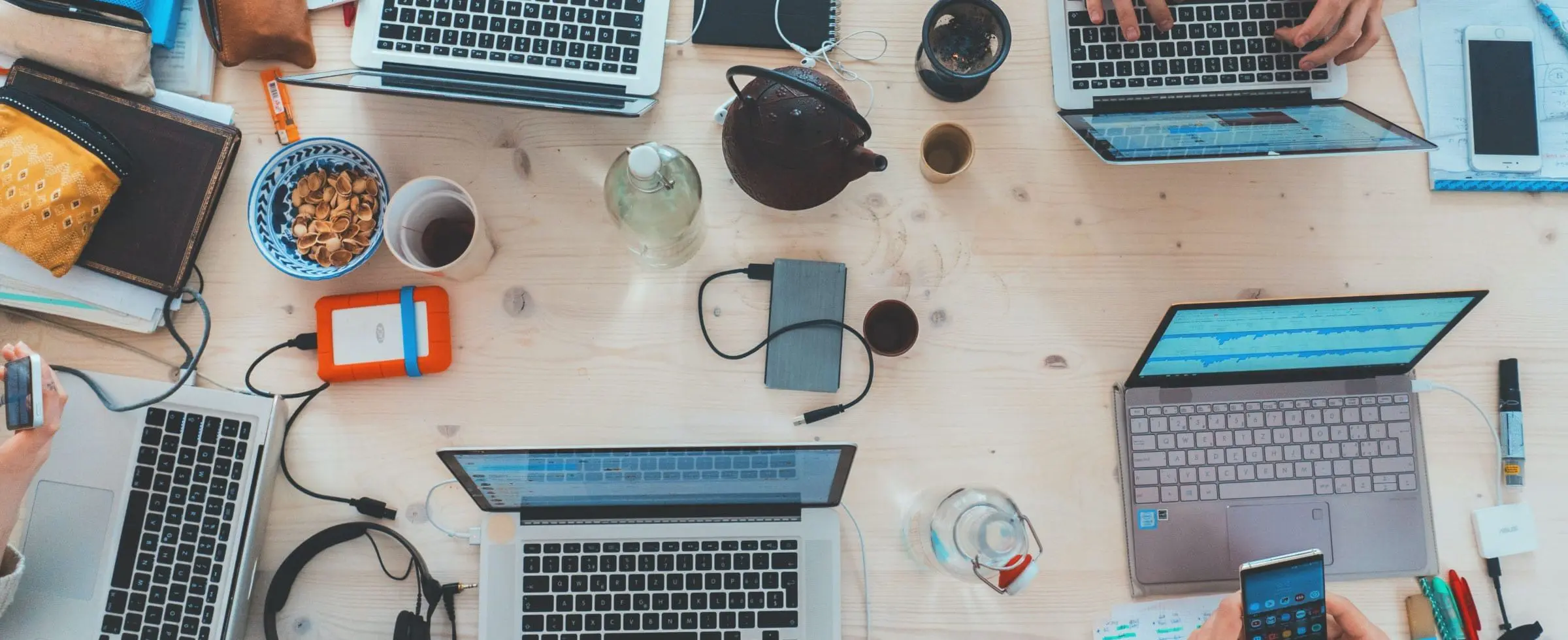 a messy desk with laptops