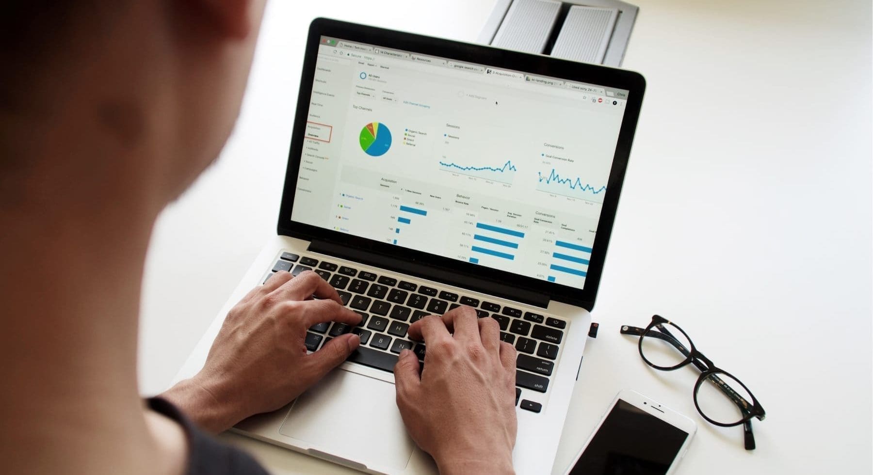 a person typing on a laptop with bars and graphs