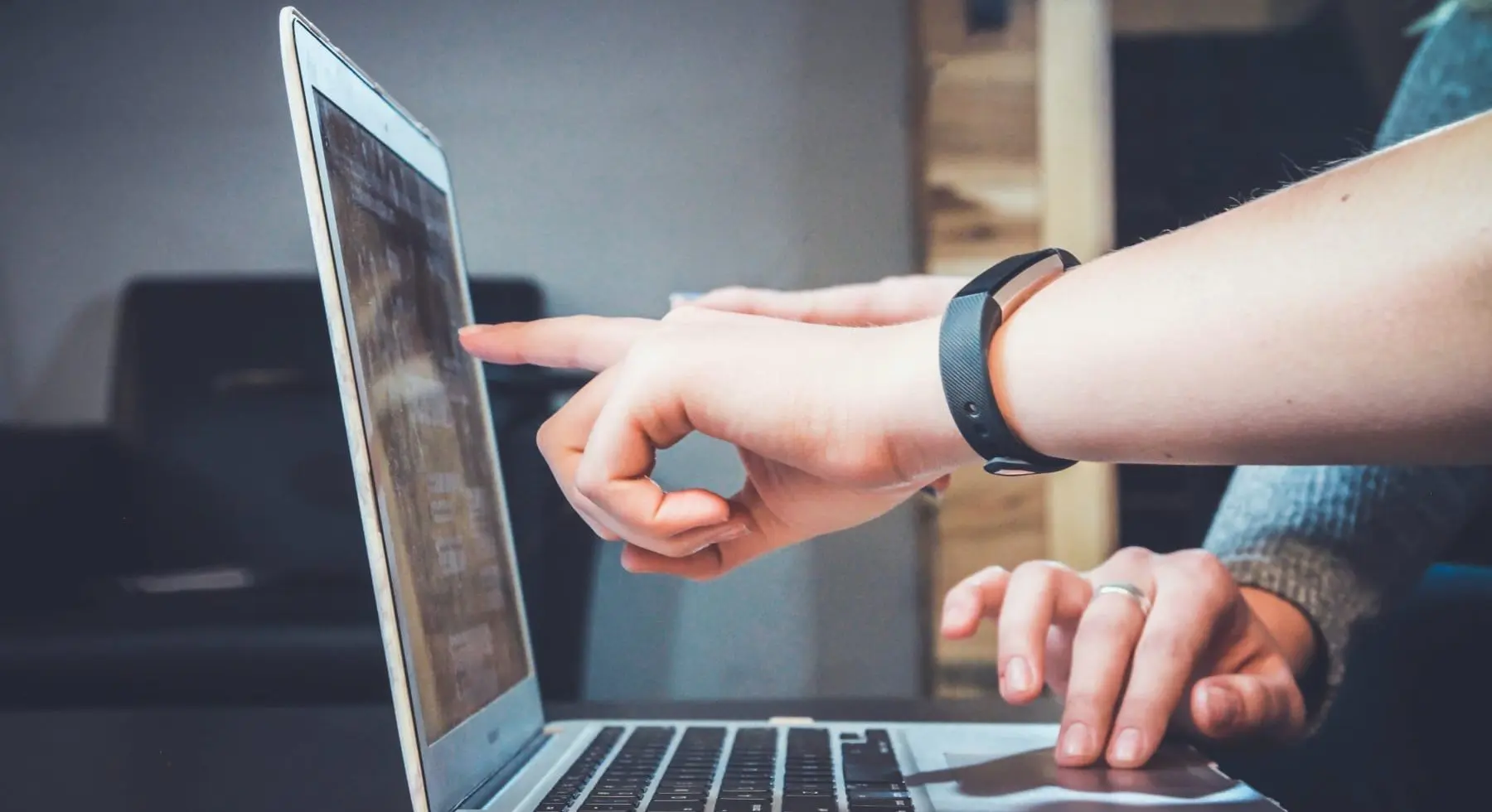 a person pointing to the laptop screen